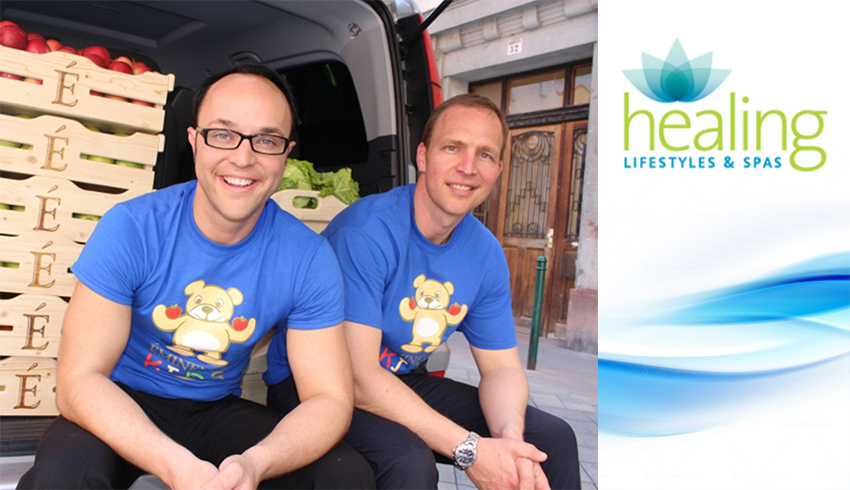 Eminence Organics President Boldijare Koronczay and General Manager Attila Koronczay seated in the back of the van filled with donations of organic fruit in wooden crates.